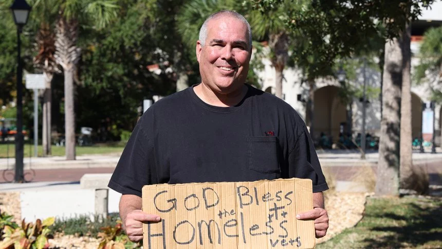 Jeff Gray holding sign that says "God Bless the Homeless Vets"