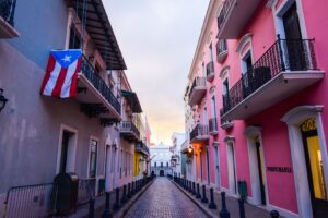 Puerto Rican street with Puerto Rican flag hanging from balconey