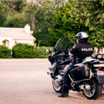 Image of police officer on a motorcycle that is sitting stationary on a street.